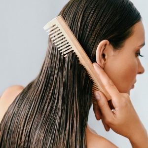 Frau kämmt nasse Haare